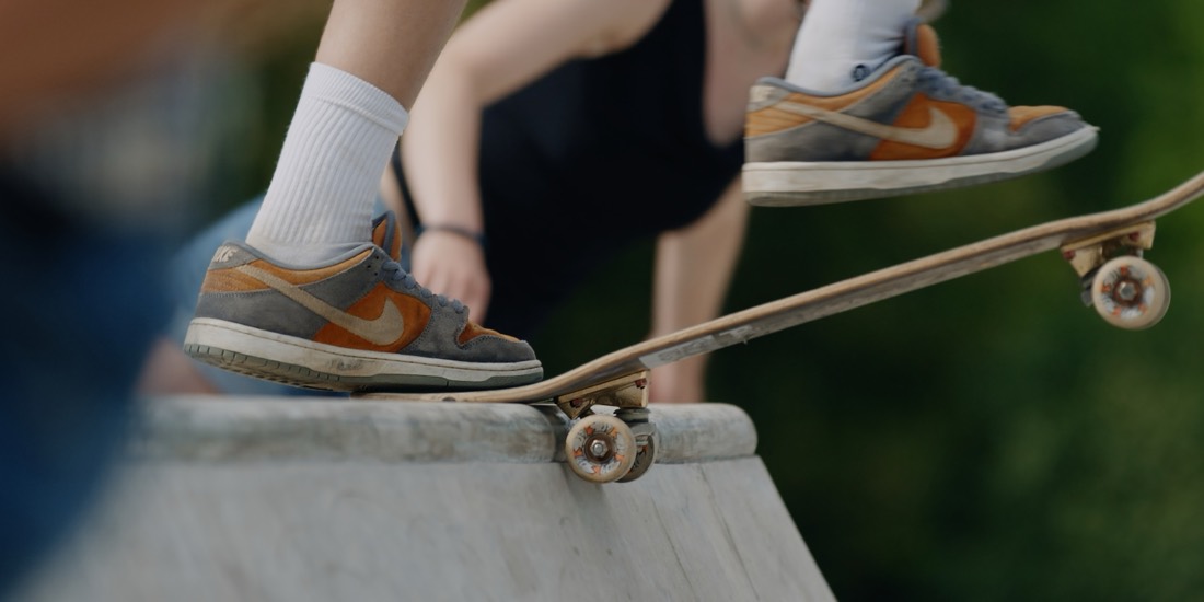 Skateschuh auf der Nase eines Skateboards an einer Betonkante